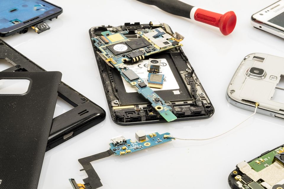 Celular desarmado con sus piezas sobre la mesa de trabajo